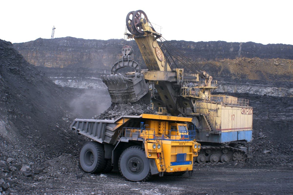 Operator ascending a staircase beside a mining dune